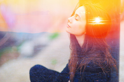 Picture of a woman sitting against a wall with double exposure technique showing the sunset reflecting on her head. Coaching for creative people and counseling for creative people can help in Richmond, VA and Baltimore, MD or via online therapy for artists and creatives in Maryland and Virginia.