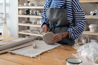 Picture of a woman making pottery wearing an apron. You can get concierge counseling for creative people in the United States, Canada, and the United Kingdom here.