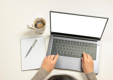Picture of hands stuck on a laptop with a blank screen, with a blank pad of paper and pen and coffee. Creative people and working artists in Maryland and Virginia can get help with Creation Translation with a creativity coach near Richmond, VA or Baltimore, MD here. 