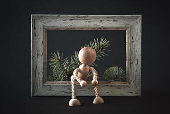 Picture of a wooden doll on a wooden holiday background frame. A concierge therapist from Richmond, VA can provide creativity coaching in Canada, the US, the United Kingdom, and beyond.