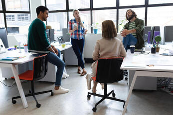 Picture of a group of professional creatives in an office. Creativity coaching intensives with a creativity coach can be paid for with grants for artists in Germany, Canada, the United Kingdom, and beyond.
