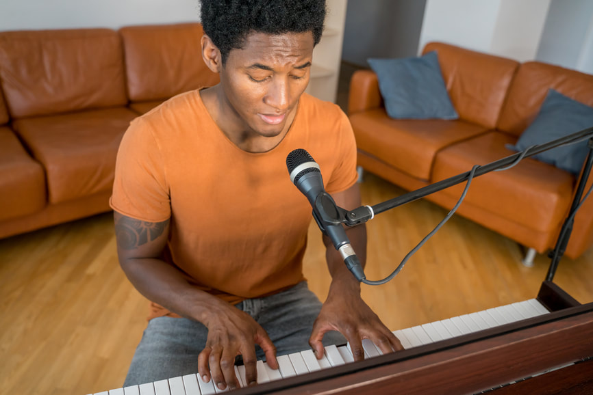 Black Musician in Home Studio at piano keyboard and microphone, seated creating music |  Online Creativity Coach Cindy Cisneros: Creativity Coaching for Musicians in GA, MD, NY, CA, UT, ME and beyond