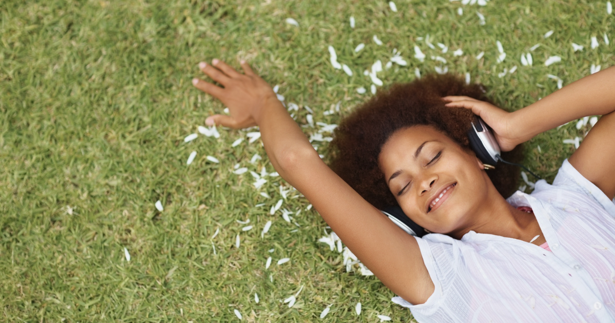 Therapy for Artists, Counseling for Artists, Therapy for Artists in Maryland, Therapy for Artists in Virginia, Concierge Counseling for Artists in Maryland |  Black Young Adult Female smiling, reclined in grass, with headphones, daytime